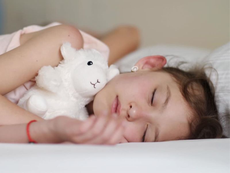 Devojčica grli plišanog medu i spava