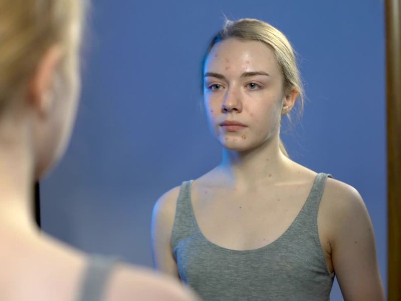 Devojčica koja je ušla u pubertet stoji ispred ogledala i gleda se