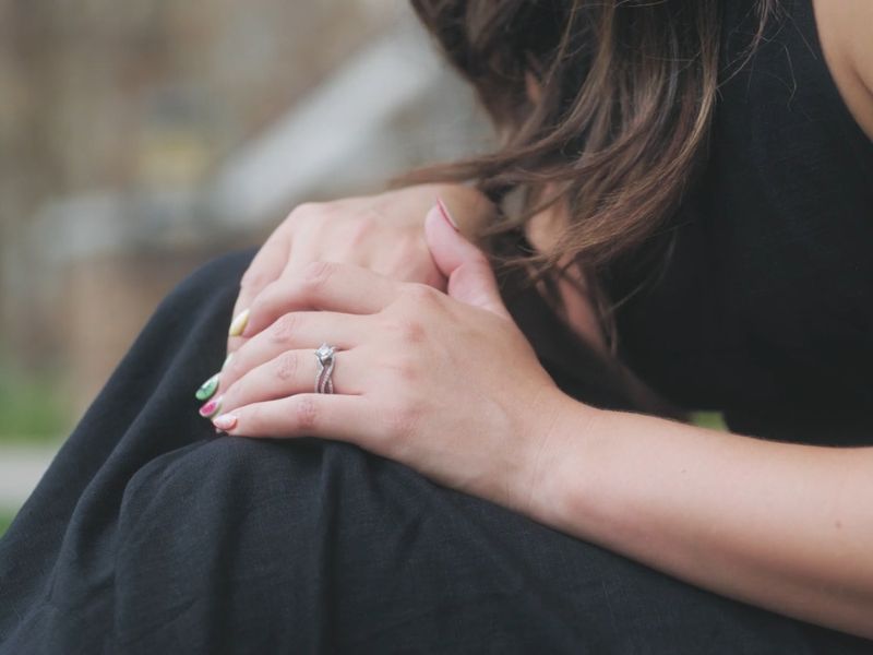 Devojka u crnoj haljini nosi verenički prsten