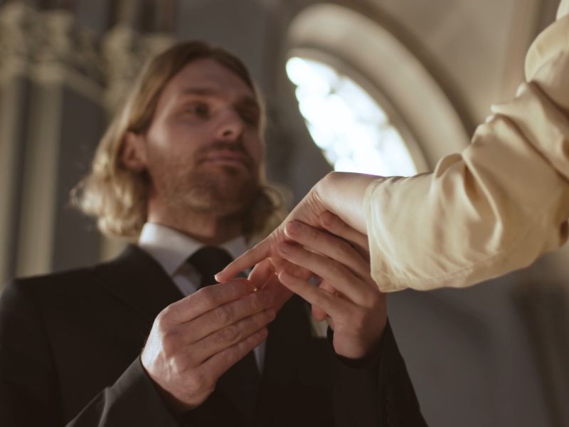 Momak stacvlja devojci verenički prsten na ruku